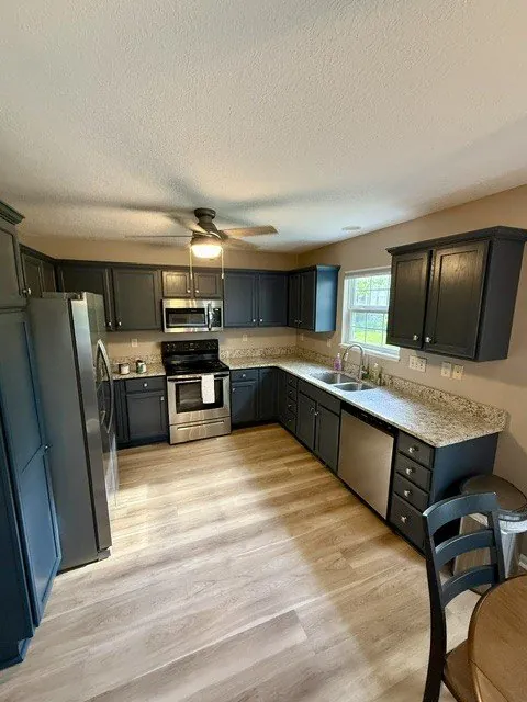 Remodeled kitchen with navy cabinets and stainless appliances